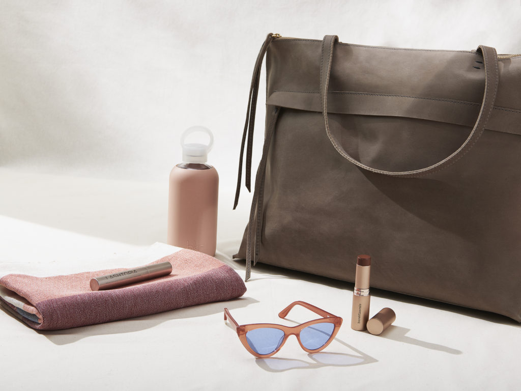 Weekender bag with bkr water bottle, sunglasses, bareminerals makeup and minna towel.