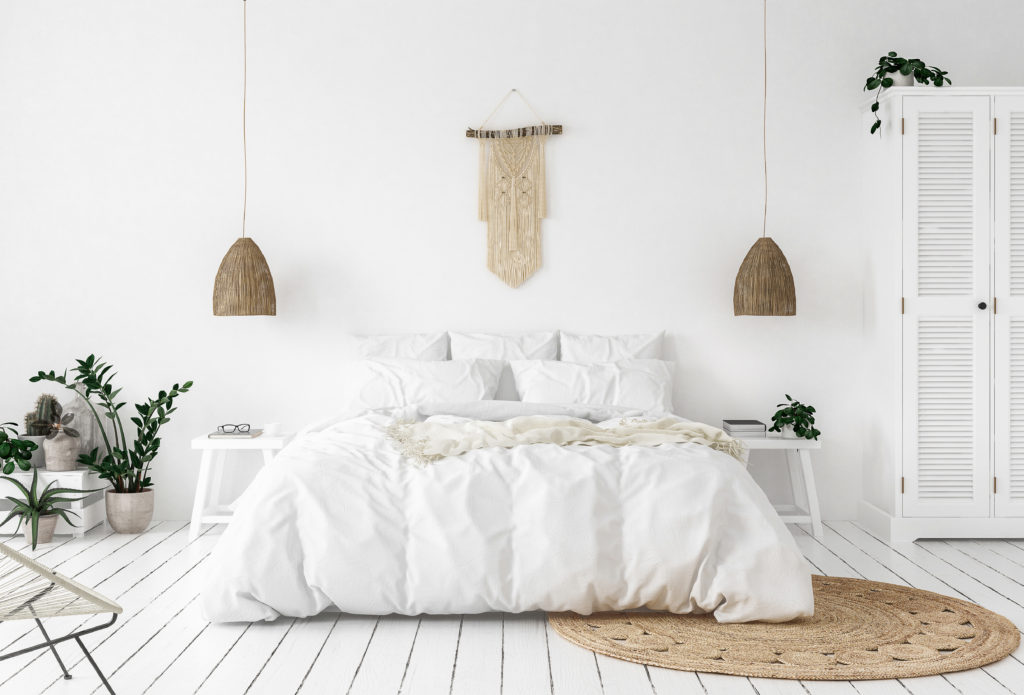 bedroom with crisp white linens, plants and a natural jute rug